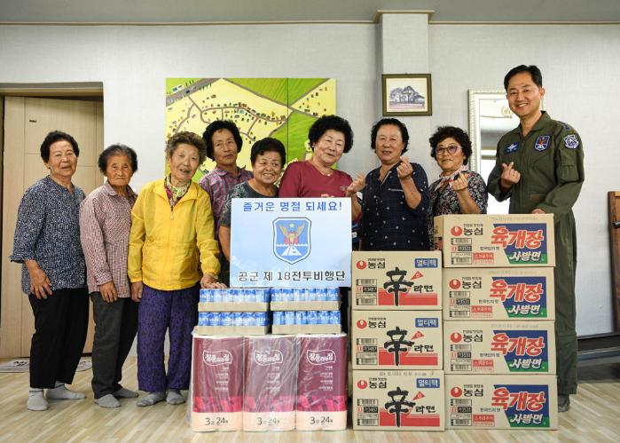 지난 22일 공군18전투비행단 장병이 부대 인근 마을회관을 찾아 위문품을 전달한 뒤 기념 촬영을 하고 있다.