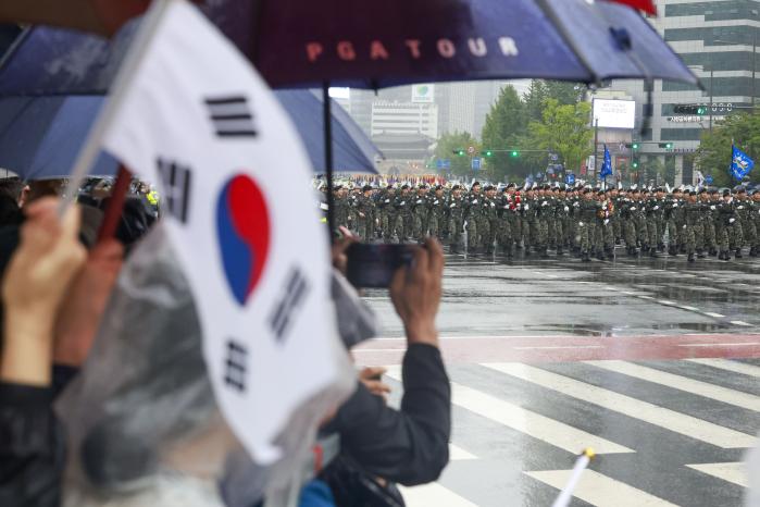 한 시민이 휴대전화로 시가행진 모습을 촬영하고 있다.
