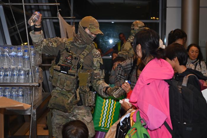 공군 공정통제사들이 공군 KC-330 탑승에 앞서 우리 교민들에게 필요한 물품을 나눠주고 있다. 공군 제공