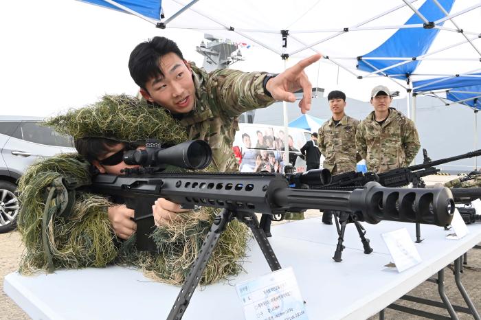지난 11일 해군1함대사령부 부대개방행사에 방문한 시민이 군복착용체험존에서 저격수용 위장복인 길리슈트를 입고 사격 자세를 취하고 있다. 부대 제공