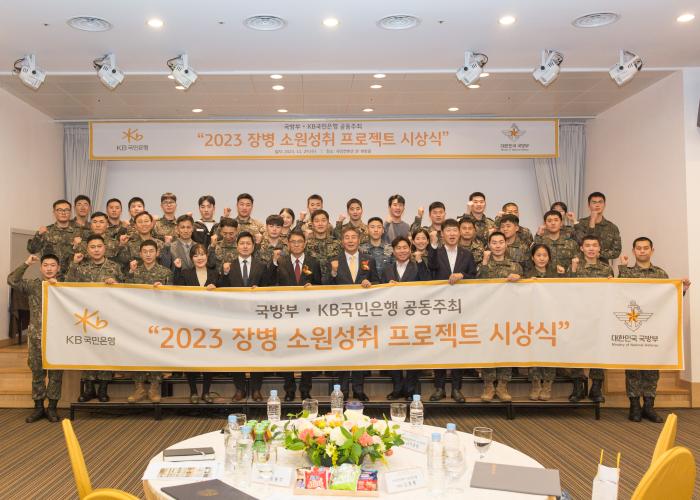 윤봉희 국방부 정책기획관이 29일 서울 용산구 국방컨벤션에서 개최된 ‘2023년 장병 소원 성취 프로젝트’ 시상식에서 김동록(부행장) KB국민은행 기관고객그룹대표를 비롯한 수상 장병, 관계자들과 기념사진을 찍고 있다. 국방부 제공