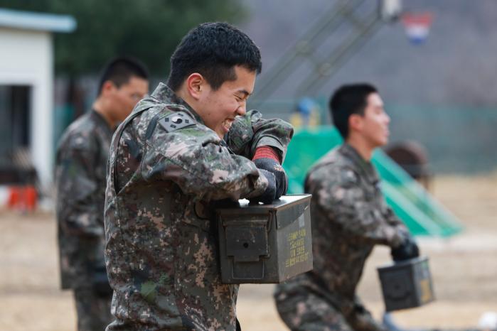 탄통 들어 올리기를 하는 장병들.