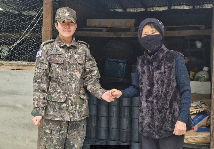 육군21보병사단 백호여단 이오르난(왼쪽) 소위가 강원도 양구군 국토정중앙면 주민에게 연탄 500장을 기부하고 있다. 부대 제공