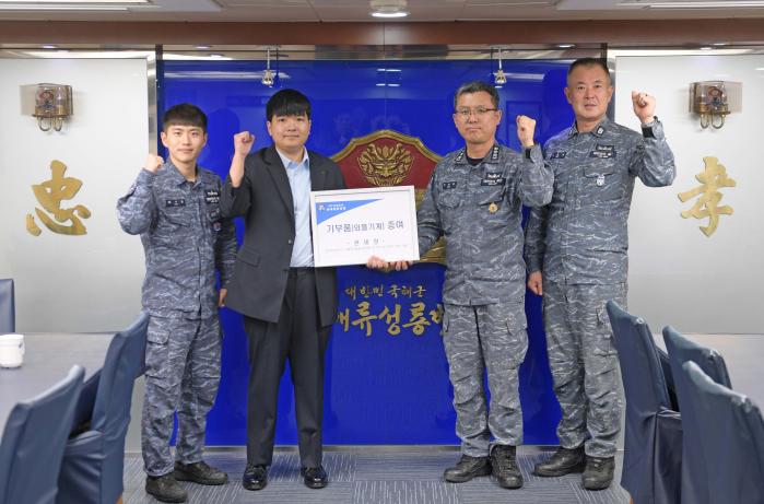 해군7기동전단 서애류성룡함 출신 예비역 병장 권세랑(왼쪽 둘째) 씨가 23일 백준철(대령) 함장 등 승조원들에게 기부물품을 전달한 뒤 증여식을 하고 있다. 부대 제공