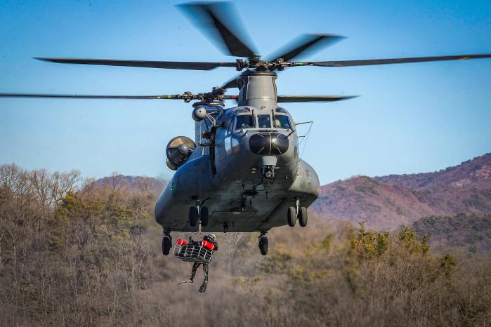 항공구조사와 조난자를 끌어올리는 HH-47 탐색구조헬기.