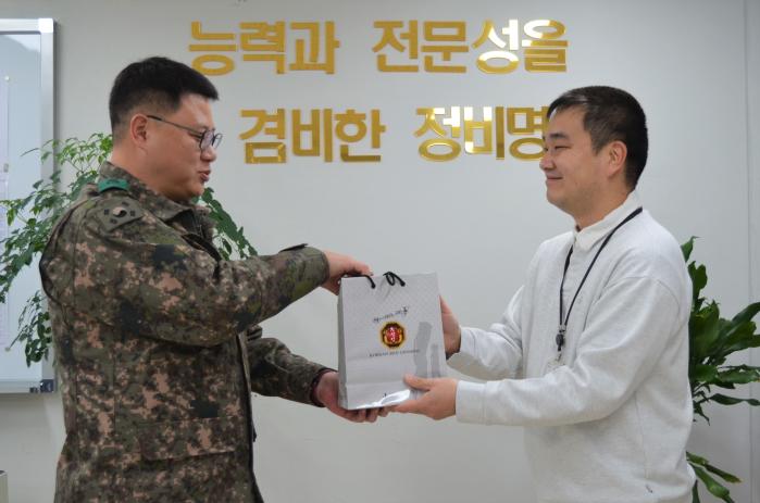 김현수(중령·왼쪽) 육군3군수지원여단 정비대대장이 다자녀 가정의 김광필 군무주무관에게 위문품을 전달하고 있다. 부대 제공