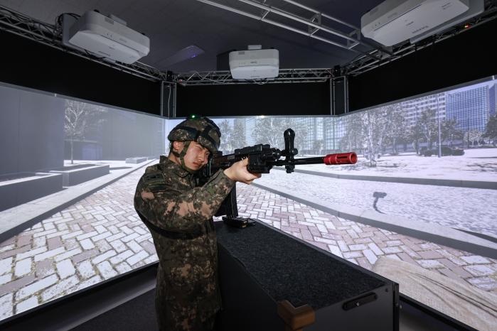 가상현실(VR) 장비를 착용한 장병이 정밀사격시스템을 활용해 벽면에 출현한 적을 제압하고 있다.