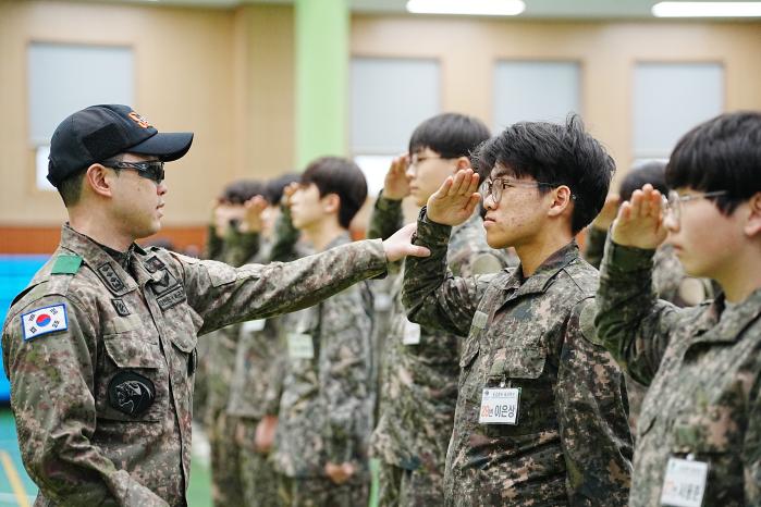 육군1군단 특공연대 교관이 22일 부대에서 열린 하나고등학교 신입생 병영체험 중 경례 자세를 알려주고 있다. 부대 제공