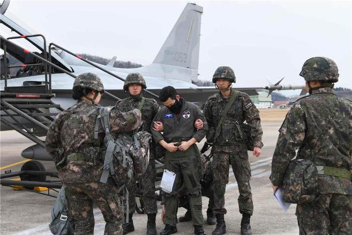 공군8전투비행단 장병들이 귀순항공기 유도처리 훈련 중 귀순 조종사 신병을 처리하고 있다. 사진 제공=김민 하사