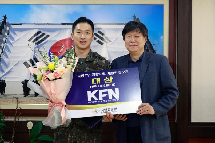 11일 서울 용산구 국방홍보원에서 열린 '국방TV·FM 채널명 공모전' 시상식에서 'KFN' 이름을 제안해 대상을 받은 육군1보병사단 최승호(왼쪽) 대위가 채일 원장으로부터 상장과 상금을 받은 뒤 기념사진을 찍고 있다.  김병문 기자