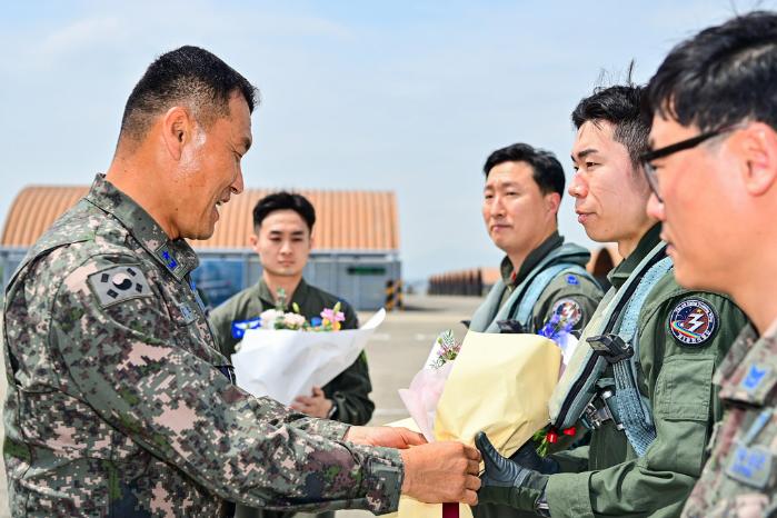 김관호(준장·왼쪽) 공군3훈련비행단장이 23일 213비행교육대대의 ‘25만 시간 무사고 비행’ 대기록을 달성한 김진 중위에게 꽃다발을 전달하고 있다. 공군 제공