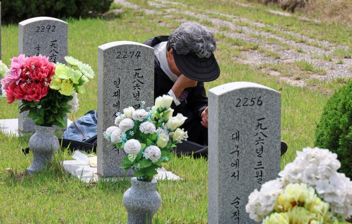 지난 26일 오전 국립대전현충원에서 순직의무군경인 고(故) 이태석 이병 어머니가 아들 묘비 앞에서 눈물을 흘리고 있다. 연합뉴스