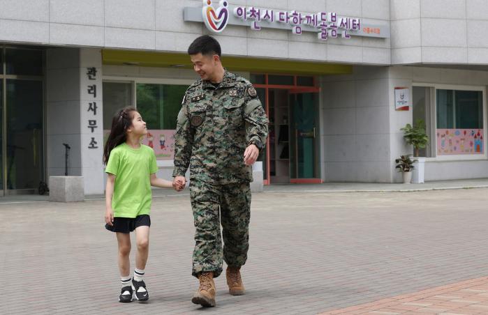 육군특수전사령부 안전장교 송병열 소령이 지난달 30일 경기도 이천시 아름수리아파트 단지 내 다함께돌봄센터 앞에서 딸 송은서 양의 손을 잡고 집에 가고 있다. 송 소령은 방과 후에도 아이를 맡길 수 있는 센터의 도움을 받아 임무 수행에 최선을 다하고 있다.