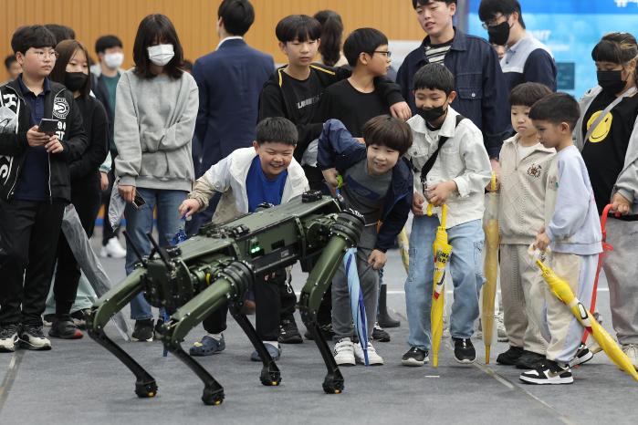 유·무인 복합전투체계 전시회에서 어린이들이 다족보행 로봇을 보고 있다.