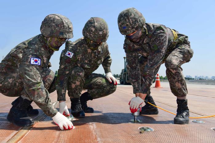 공군1전투비행단과 해군3함대 장병들이 9일 합동 활주로 피해복구 훈련에서 접개식 유리섬유 매트를 고정하고 있다. 사진 제공=박형준 일병