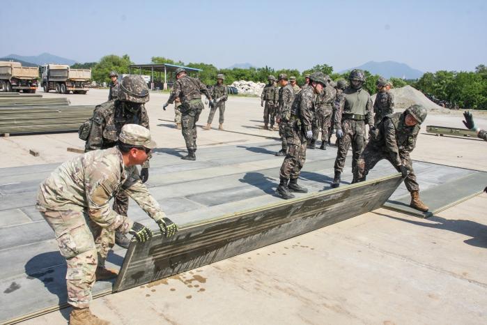 지난 16일 충북 충주시 중원비행장에서 열린 한미 연합 합동 공병훈련 중 육군2작전사령부 1115공병단 공병대대와 미2사단/한미연합사단 11공병대대 장병들이 활주로에 생긴 화구를 복구하기 위해 매트를 조립하고 있다. 부대 제공