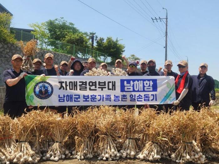 해군5전단 남해함 장병들이 경남 남해군 참전용사 가족을 찾아 마늘 수확을 도운 뒤 사진을 찍고 있다. 사진 제공=정재웅 대위