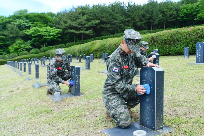 제주도 충혼묘지 태극기·꽃 심기 캠페인에 참가한 해병대9여단 장병들이 묘비를 정리하고 있다. 사진 제공=김태형 병장