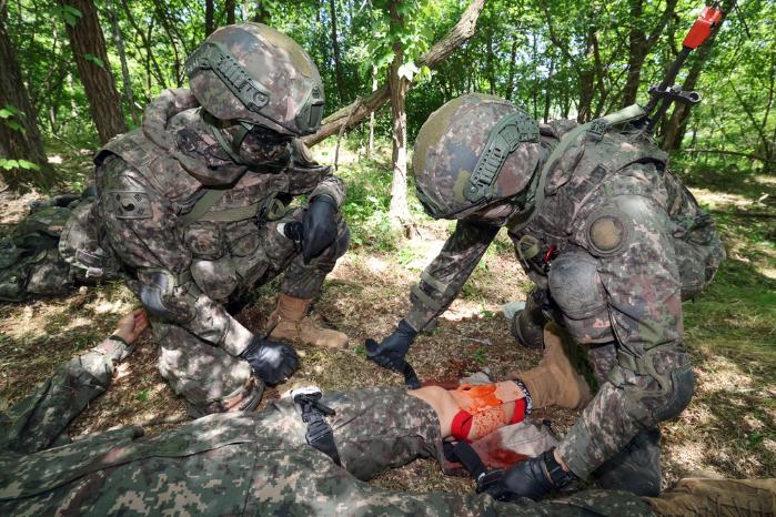 을지여단 장병이 총상을 입은 전투원의 다리에 지혈대를 감고 있다.