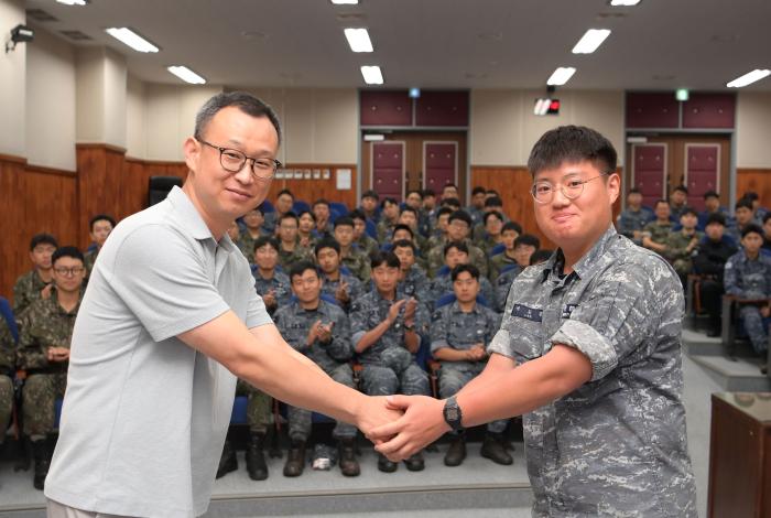 지난 7일 해군2함대사령부에서 진행된 초빙 강연에서 제2연평해전 참전용사인 권기형(왼쪽) 예비역 병장과 한상국함 이도경 병장이 손을 맞잡고 있다. 부대 제공