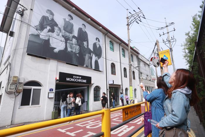 지난 4월 서울 성동구에 문을 연 그룹 방탄소년단(BTS)의 팝업스토어 'BTS 팝업 : 모노크롬'을 찾은 해외팬들이 사진을 찍고 있다. 연합뉴스