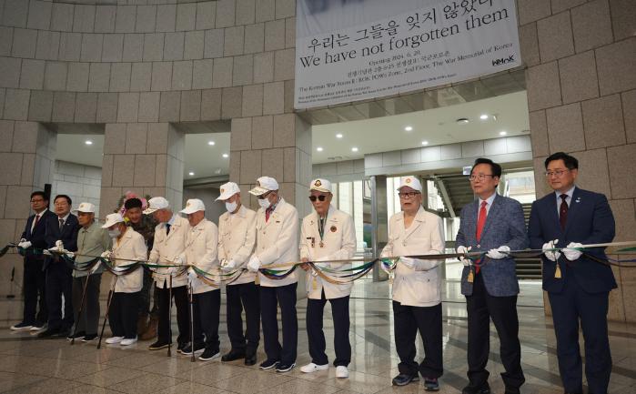 20일 서울 용산구 전쟁기념관에서 열린 ‘국군포로 전시실’ 개관식에서 귀환 국군포로 출신 참전용사들을 비롯한 참석자들이 테이프를 자르며 개관을 축하하고 있다. 양동욱 기자