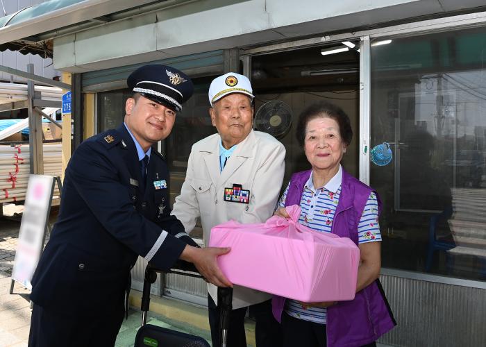 공군18전투비행단 이재원(왼쪽) 주임원사가 호국보훈의 달을 맞아 최준규 옹 부부에게 위문품을 전달하고 있다. 사진 제공=유영임 상사