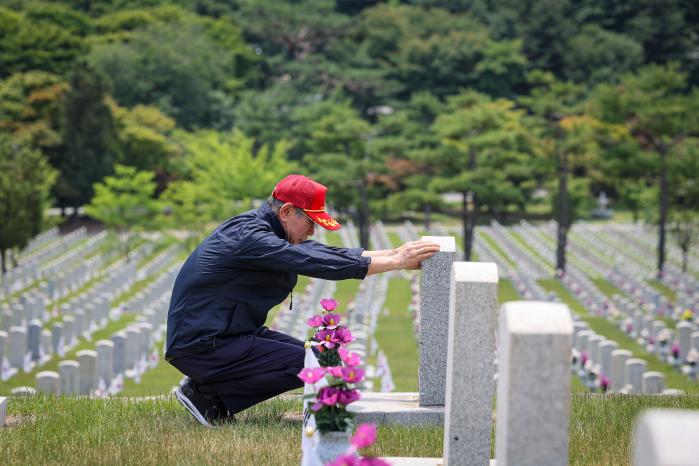 김부광 씨가 국립서울현충원에 안장된 아버지 고(故) 김형욱 일병의 비석을 어루만지고 있다.