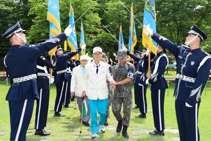 공군교육사령부가 26일 개최한 6·25전쟁 참전용사 초청 행사에서 참전용사들이 도열한 의장대 사이로 입장하고 있다. 부대 제공