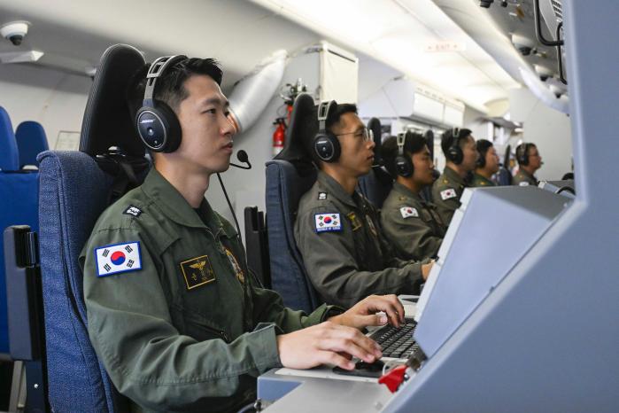 전술통제관(맨 왼쪽)과 P-8A 승무원이 전술훈련을 하고 있다.