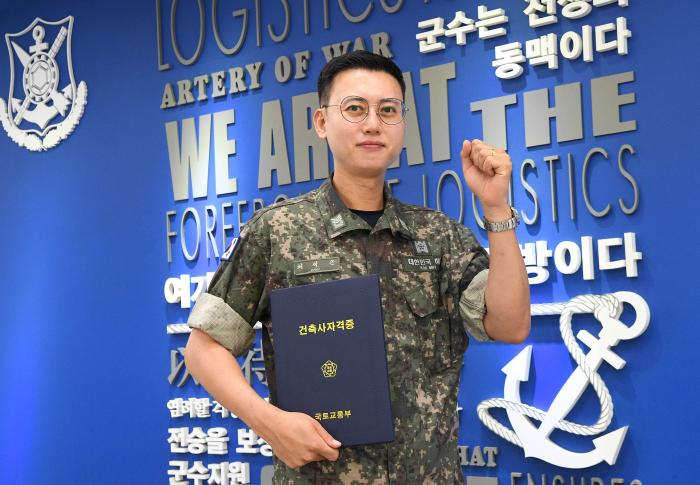 해군군수사령부 병기탄약창 최석근 상사가 최근 취득한 건축사 자격증을 들고 파이팅 포즈를 취하고 있다. 부대 제공