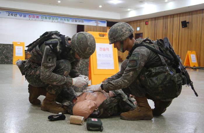 국군대구병원에서 개최된 육군2작전사령부 ‘2024년 무열 최정예 전투부상자처치팀 선발대회’ 중 참가한 장병들이 더미에 응급처치를 하고 있다. 부대 제공