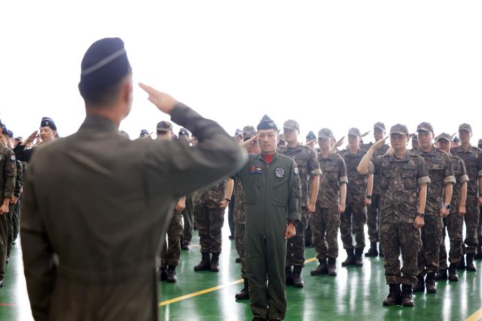 대한민국 대표 자부심으로… 장거리 비행을 앞둔 F-15K 전투기를 점검하는 정비사(위 사진)와 출정식에서 지휘관에게 경례하는 장병들.