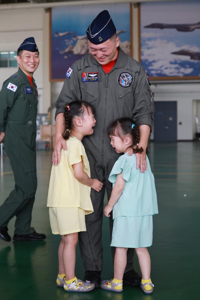 자랑스러운 아빠이기에… KC-330에 탑승하던 장병이 배웅나온 가족을 뒤돌아보고 있다. 오른쪽 사진은 피치블랙 훈련단 박용석 소령이 딸 수빈·정빈 양을 안아주는 모습.