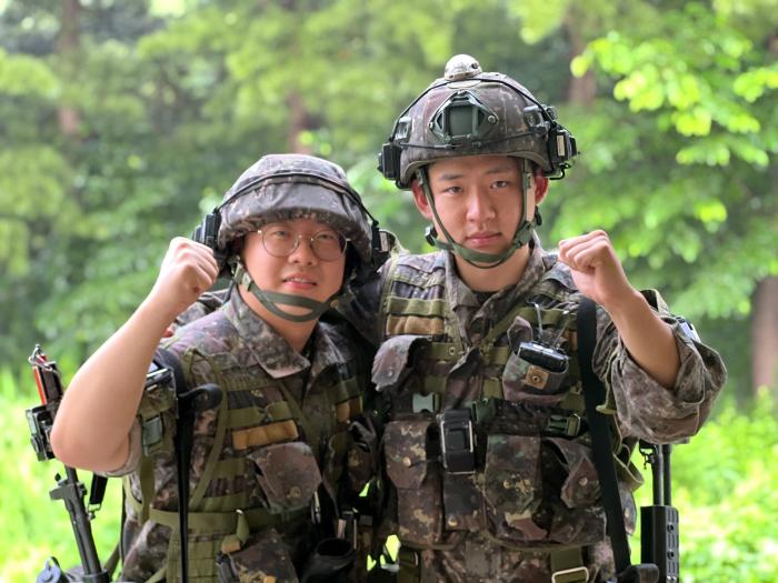 자발적으로 전역을 연기한 육군6보병사단 초산여단 이연우(왼쪽)·전영서 예비역 병장이 전역 전 마지막으로 소화한 KCTC 훈련을 마치고 파이팅을 외치고 있다. 부대 제공