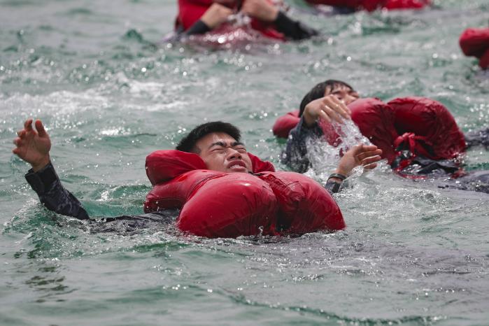 25일 해군1함대 해상생환훈련장에서 1500톤급 호위함(FF) 부산함 승조원들이 바다에 입수해 기본배영법을 실습하고 있다.