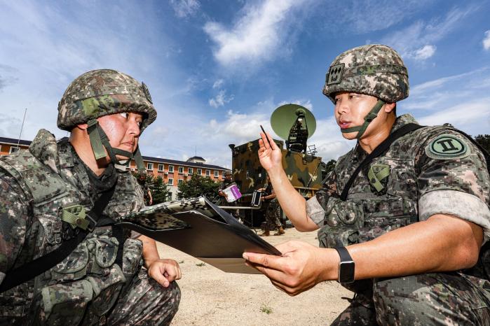 육군2군단 박정욱(오른쪽) 소령(진)이 중대원들과 함께 위성차량 운용 훈련을 하고 있다. 육군 제공