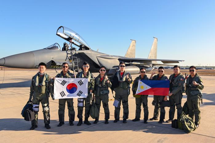 우정비행에 나선 한국·필리핀 공군 조종사들이 호주 다윈기지에 주기된 F-15K 전투기 앞에서 두 나라 국기를 들고 기념사진을 찍고 있다. 공군 제공