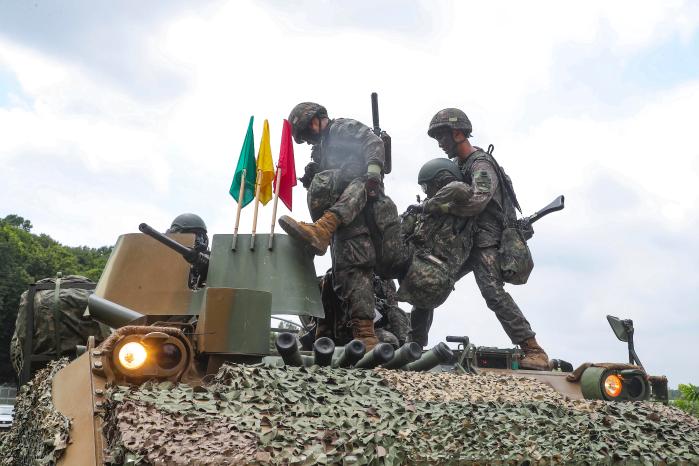 30기갑여단 승무원들이 부상당한 조종수를 구조하고 있다.