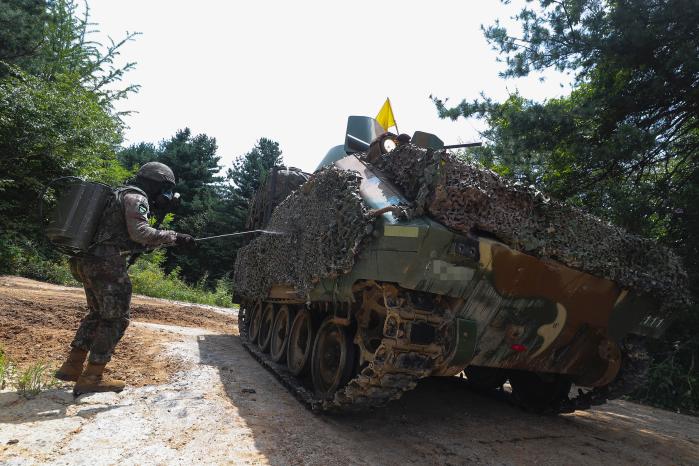 적 핵·화생방 상황에서 승무원이 장갑차를 제독하고 있다.