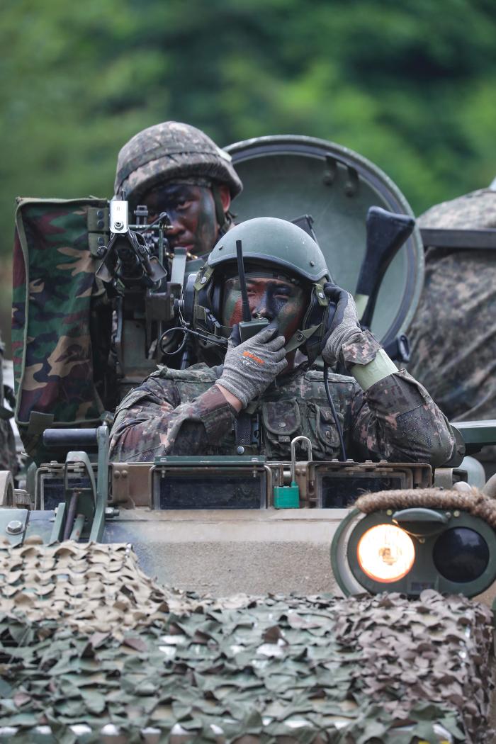 장갑차 분대장이 승무원들에게 무전으로 명령하고 있다.