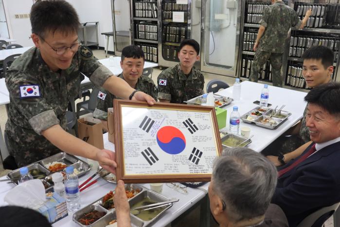 장병들의 마음을 담은 롤링페이퍼 태극기를 명경섭 옹에게 전달하는 모습.