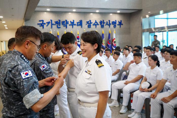 지난 2일 해군잠수함사령부 본관에서 열린 잠수함 휘장 통합수여식에서 홍승택(대령·맨 왼쪽) 91잠수함전대장이 도산안창호함 전투정보관 유효진 대위에게 금빛 돌고래 휘장을 전달하고 있다. 한재호 기자