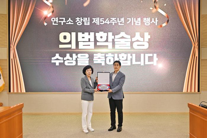 국방과학연구소 이수용(오른쪽) 선임연구원이 고 김용철 명예연구위원의 장녀 김설매 여사에게서 ‘의범학술상’ 상패를 받고 있다. ADD 제공