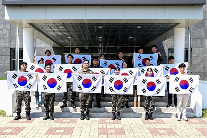 공군39비행단 초급간부들이 광복절을 앞두고 배부받은 태극기를 펼쳐 보이고 있다. 사진 제공=서진철 상사