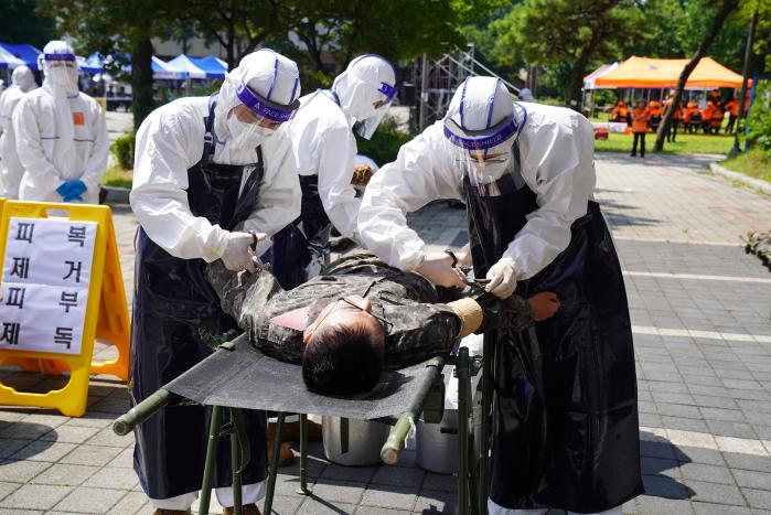 통합방위훈련에 참가한 56사단 장병들이 적 공격으로 피해를 받은 환자의 피복을 제거하고 있다.