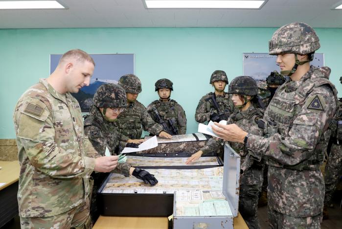 한미연합 자금수송 훈련에 참가한 육군5군단 지역자금공급팀과 미8군 176재정관리지원대 장병들이 긴급 소요자금을 인수하고 있다. 육군 제공