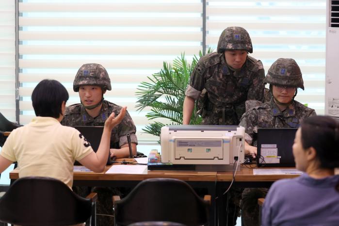 21일 공군 오산기지에서 UFS 연습의 하나로 진행된 전시 급여지급 훈련 중 급여지급팀 장병들이 지급소를 찾은 군인 가족에게 급여 수령 절차를 안내하고 있다.