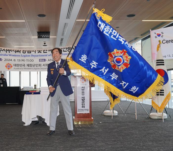 이진길 향군 호주 서부지회장이 회기를 흔들며 지회 출범을 알리고 있다.