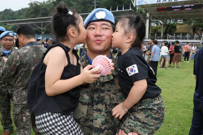 한 장병이 자녀들로부터 잘 다녀오라는 인사와 함께 볼뽀뽀를 받고 있다.